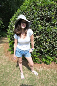 A cute and easy outfit for a hot summer day. Straw hat, white tee, denim shorts, and sandals.