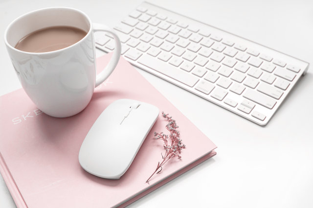 Coffee cup, mouse, pink notebook, keyboard flat lay