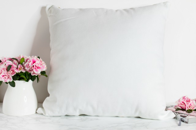 White vase, pink flowers, white pillows