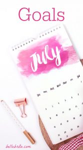 Flat lay of a July calendar and office supplies with a text overlay that reads Goals