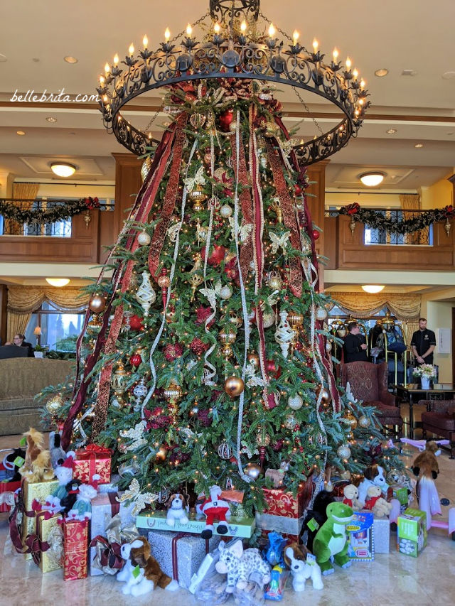 A large Christmas tree under a candle chandelier at the Inn at Biltmore