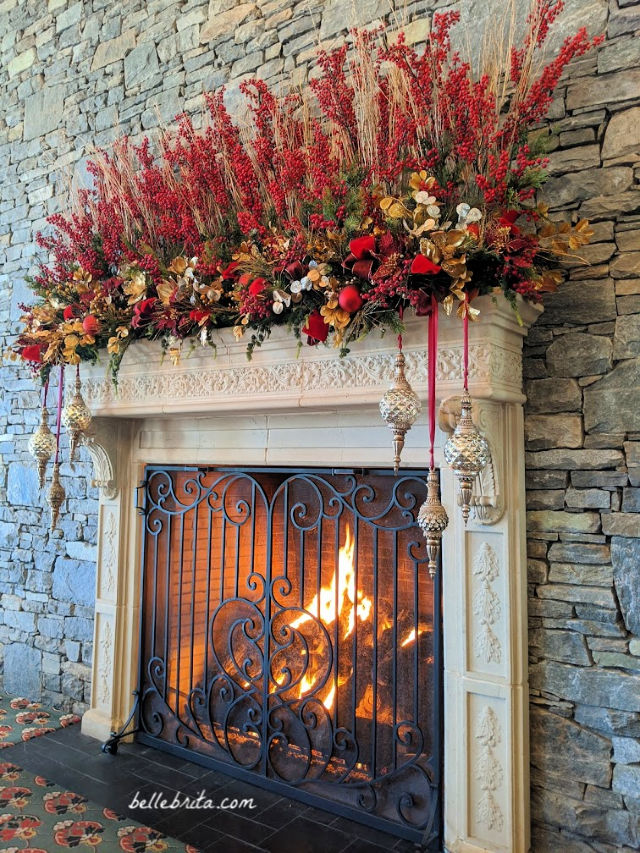 Large lit fireplace with the mantle decorated for Christmas