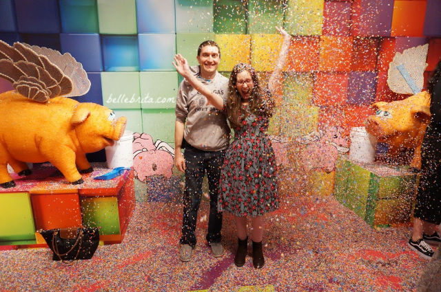 White man and white woman in a colorful room with confetti