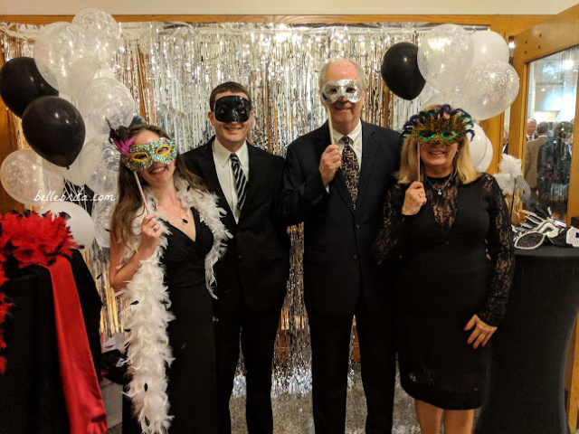 Four white people dressed up, wearing masks