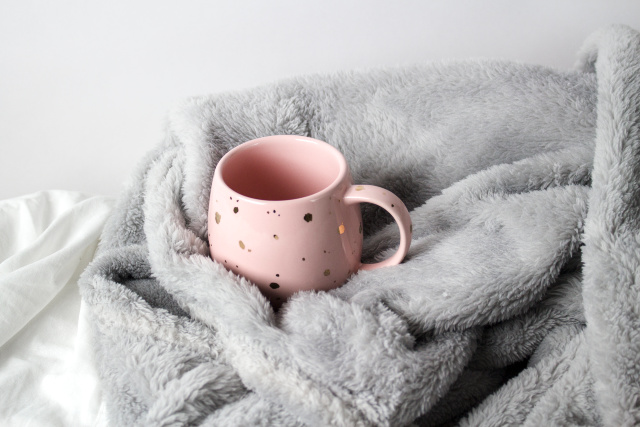 Pink and gold mug, gray blanket