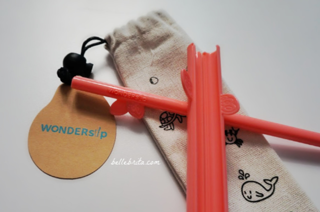 Reusable coral WonderSip Straws on a white table