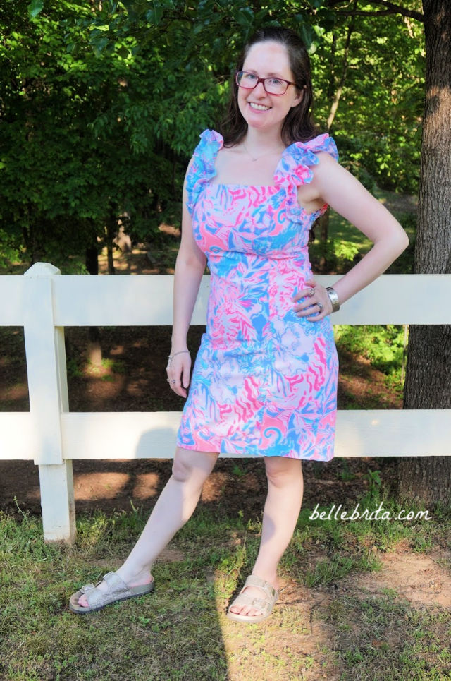 White woman wearing a pink, white, and blue Lilly Pulitzer sundress