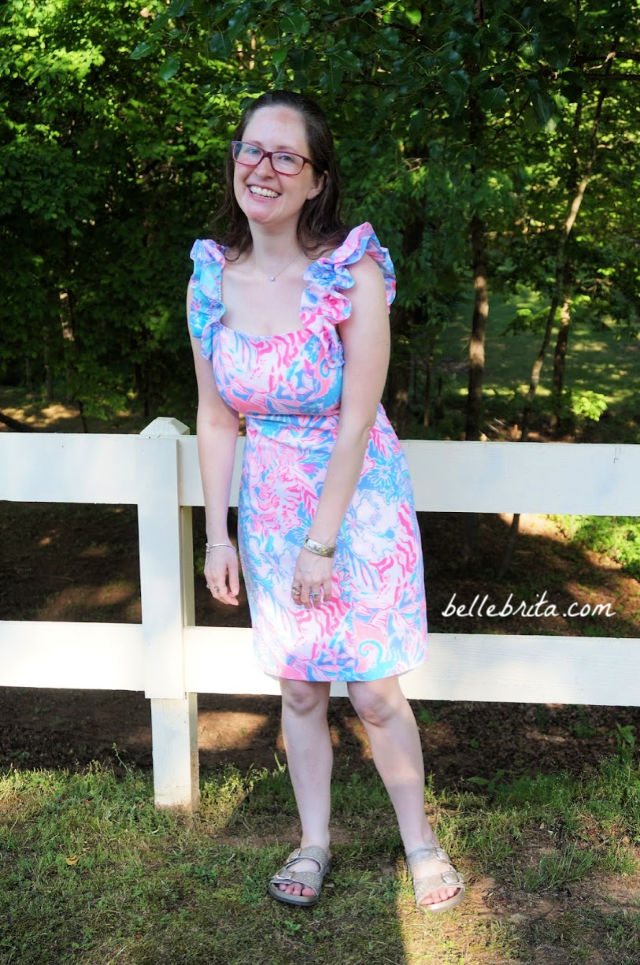 White woman wearing a pink, white, and blue Lilly Pulitzer sundress