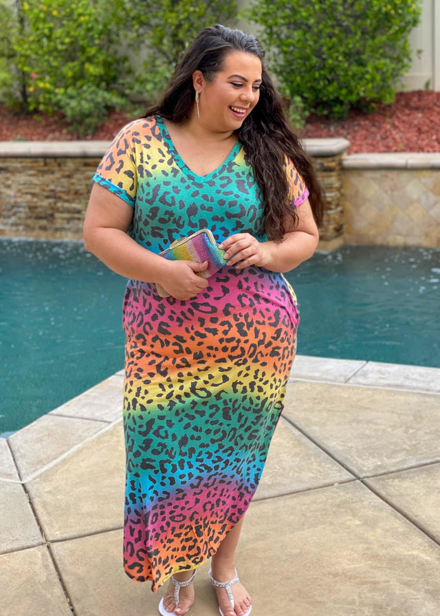 White woman wearing an animal print rainbow maxi dress