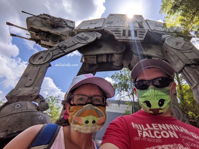 White man and white woman wearing Baby Yoda face masks outside of Star Tours in Hollywood Studios